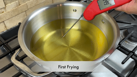 Shows the initial frying of the wings in hot oil.