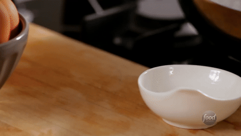 Shows eggs being cracked into small bowls.