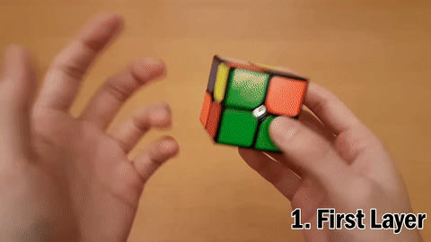 Demonstration of selecting a white piece and placing it on the bottom, followed by aligning other white pieces to complete the first layer.