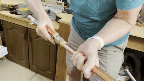 Removing the gas line and vent attachments from the water heater.