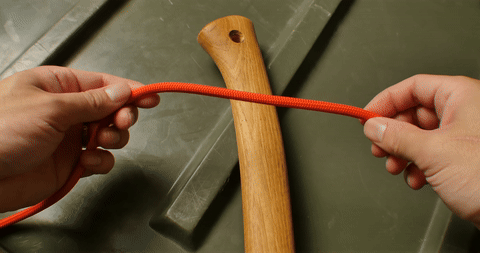 Shows the twisting of the rope to form the initial loops for the clove hitch.