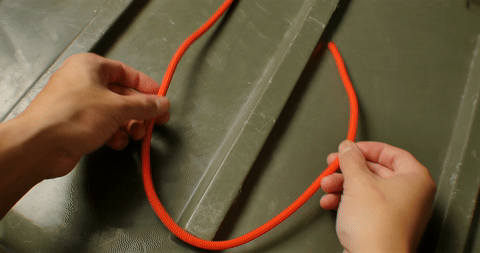 Shows the formation of an overhand loop as the first step in tying a bowline.