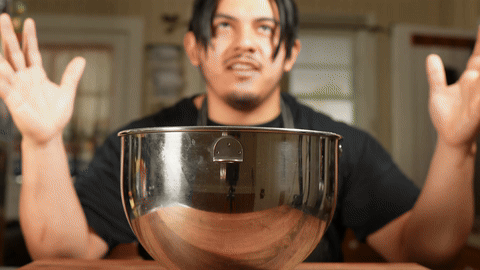 Demonstrates the kneading process and the addition of butter.