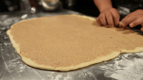 Shows the dough being rolled into a log and cut into pieces.