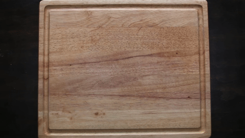 Shows the process of cutting an onion in half and peeling it.