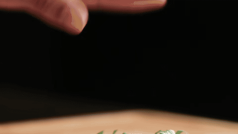 Shows stacking and rolling basil leaves.