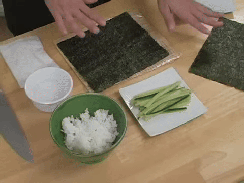 Shows all necessary materials laid out, including seaweed, rice, fillings, and B&B roller.