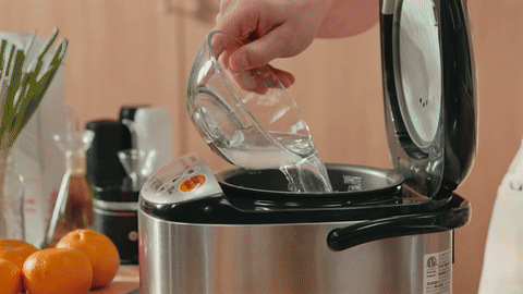 Shows the process of measuring water with a finger and starting the rice cooker.