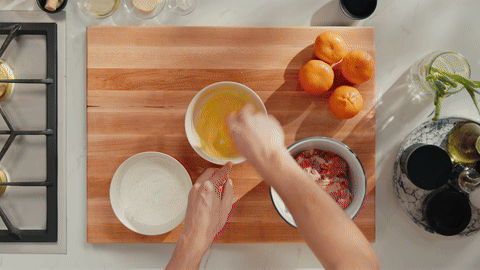 Demonstrates massaging chicken in wet dredge and coating in dry dredge.