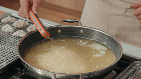 Shows chicken being fried to a golden brown color.