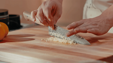 Shows sautéing garlic, ginger, and red pepper flakes.