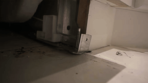 Shows the adjustment of dishwasher height and securing with brackets.