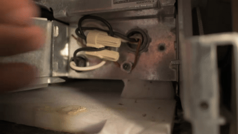 Shows the process of disconnecting the electrical wires from the dishwasher.