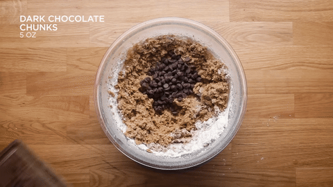Folding chocolate chips and chunks into the dough.