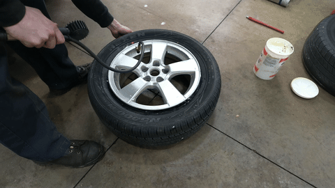 Demonstrates inflating the tire to seat the bead.