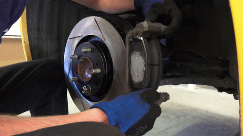 Demonstrates reattaching the brake caliper.