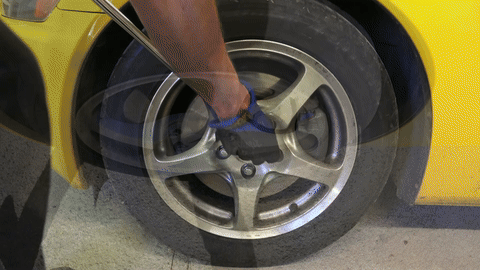 Shows the process of loosening the wheel lug nuts.