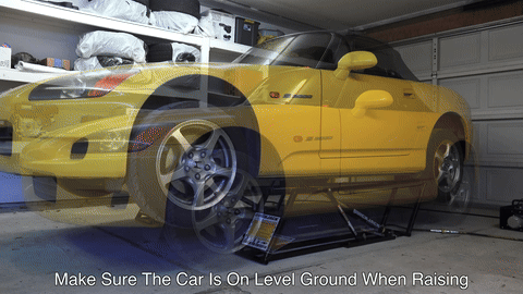 Illustrates the car being lifted using the correct jacking points.