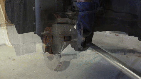 Demonstrates the removal of the brake caliper bolts.