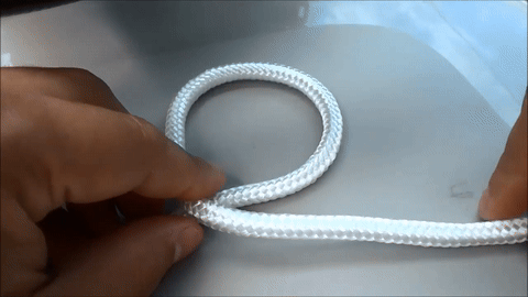 Demonstrates threading the rope end through the loop from underneath.