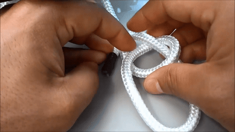 Demonstrates threading the rope end through the top loop.