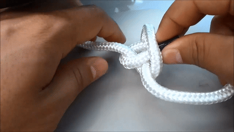 Shows the final tightening of the knot.