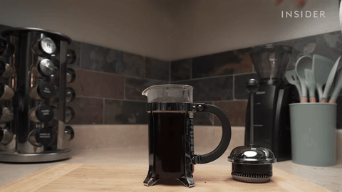 Shows placing the plunger on the French press.