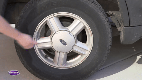 Demonstration of removing hubcaps with a flat-headed tool.