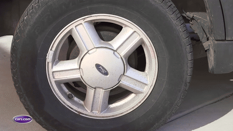 Loosening lug nuts with a wrench.