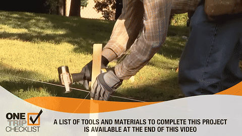 Demonstrates marking the spots for fence posts by hammering stakes.