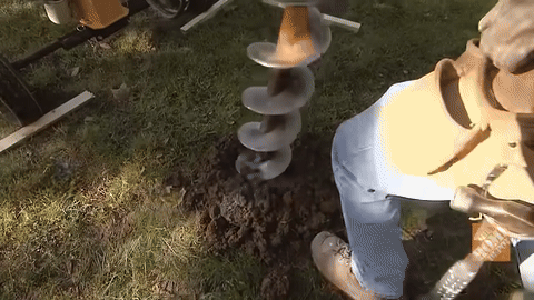 Illustrates digging post holes with a power auger.