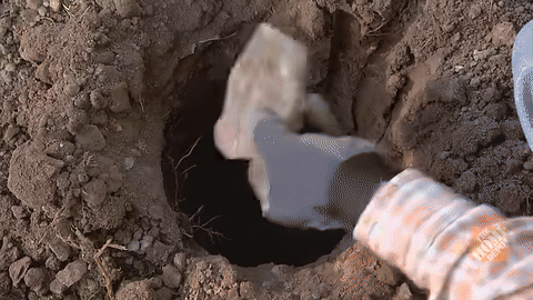 Displays pouring and tamping gravel into the hole.