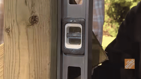 Illustrates using a level to check post verticality.