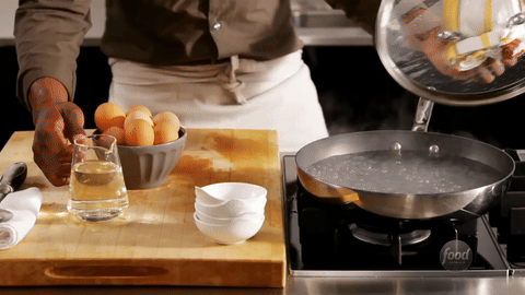 Demonstrates adding vinegar to the boiling water.