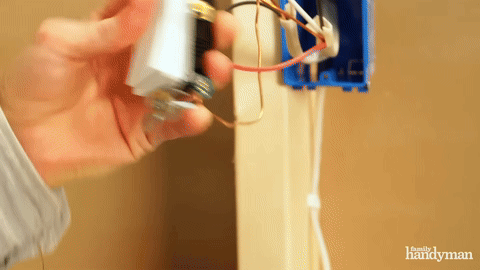 Installing the first switch into the electrical box.