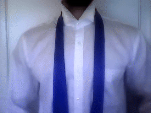 Shows the initial positioning of the tie with the wide end in the right hand and narrow end in the left hand.