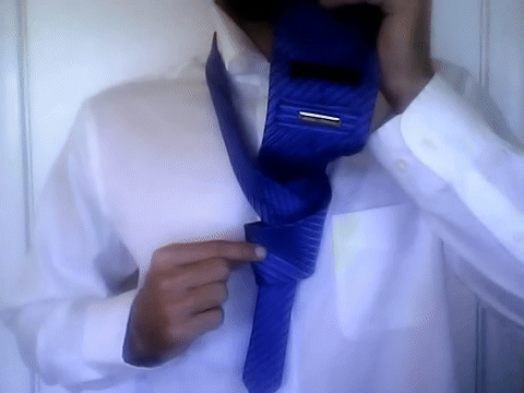 Illustrates pushing the wide end through the knot and straightening it.