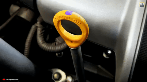 Shows the dipstick being pulled out and wiped clean.