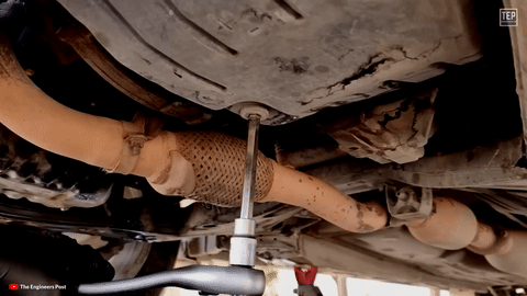 Shows the transmission fluid pan being removed.