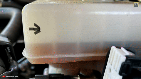 Shows brake fluid being added to the reservoir.