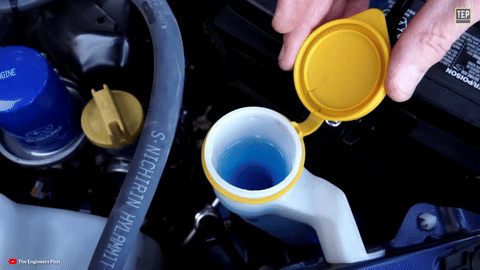 Shows washer fluid being checked and topped off.