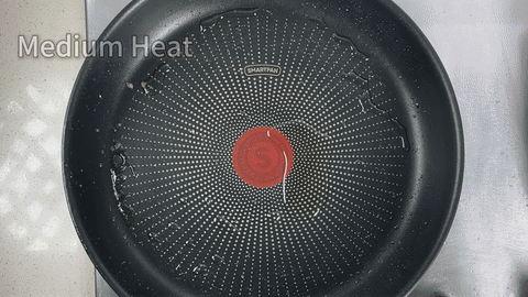 Shows the aromatics being stir-fried in the pan.