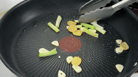 Shows the final combination of beef and sauce with a high-heat stir fry.